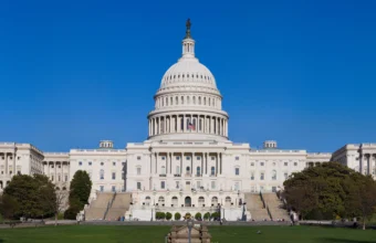 The United States Capitol building west front under a clear blue sky in Washington, D.C.