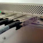 Close-up of an InfiniBand network switch with multiple cables connected, representing the network layer a Capsule Server proxies and caches for distributed RHEL fleets