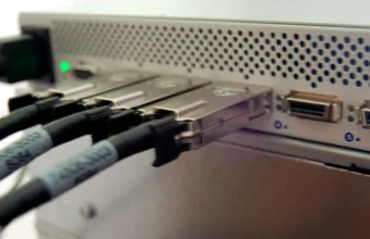 Close-up of an InfiniBand network switch with multiple cables connected, representing the network layer a Capsule Server proxies and caches for distributed RHEL fleets