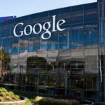 The Google logo on the glass facade of a building at Google's Googleplex headquarters