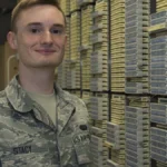 Network operations technician in a server room with racks and cabling