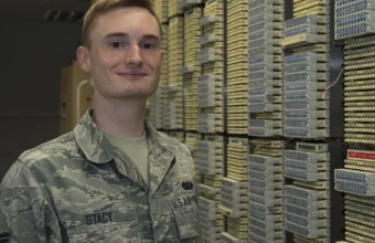 Network operations technician in a server room with racks and cabling