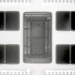 Near-infrared macro photograph of a delidded AMD EPYC 7702 server processor, showing the central I/O die and eight surrounding Core Complex Dies
