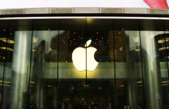 Illuminated Apple logo above the glass entrance of an Apple Store in Beijing, China