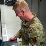 U.S. Air Force network systems technician performing server maintenance in a data center