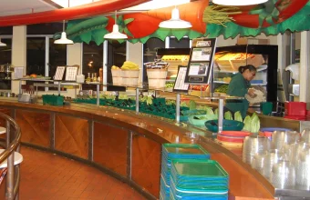 A self-serve cafeteria salad bar with individual bins, tongs, and stacked trays, illustrating selective access instead of an all-or-nothing choice