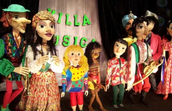 Colorful marionette puppets with visible control strings at a puppet theater stage, a visual metaphor for CSRF attacks making a browser act on hidden strings