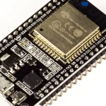 Close-up photo of an ESP32-WROOM-32 development board showing its micro USB port, module, GPIO pins, and EN and BOOT buttons used for flashing firmware