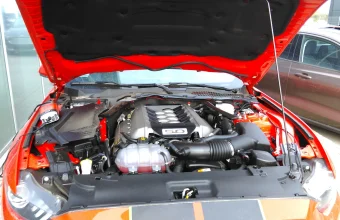 A red Mustang GT's hood raised to show its rebuilt 5.0-liter V8 engine bay