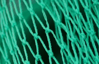 Extreme close-up of a green woven HDPE construction safety net
