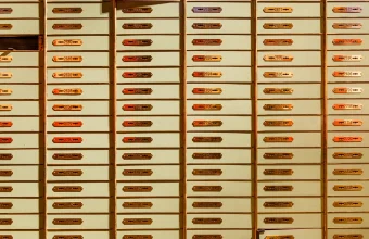 Rows of individually numbered, individually locked safe deposit boxes inside a bank vault
