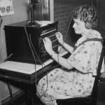A 1936 photo of a telephone switchboard operator plugging a connection into a manual switchboard, used as a visual metaphor for AI model routing
