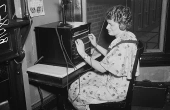 A 1936 photo of a telephone switchboard operator plugging a connection into a manual switchboard, used as a visual metaphor for AI model routing