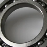 Close-up of a ball bearing showing individually spaced steel balls arranged evenly around a metal ring