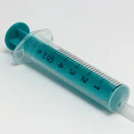 A clear and teal 5ml single-use medical syringe lying diagonally on a white background, used as a visual metaphor for SQL injection attacks