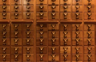 Rows of small labeled wooden drawers in a library card catalog, a visual analogy for AI memory entries organized and searchable by topic