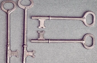 Four antique skeleton keys resting on a blue background