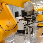 Yellow robotic arms perform automated chemical genomics drug screening in a laboratory