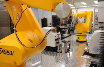 Yellow robotic arms perform automated chemical genomics drug screening in a laboratory