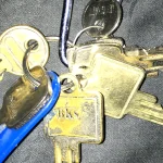 A cluster of physical keys on a keyring, representing the many permission scopes available versus the one a workflow actually needs