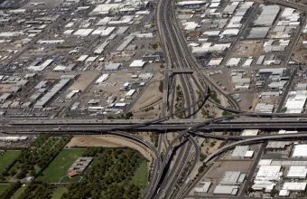 Aerial photo of a multi-level highway interchange with several lanes of traffic merging and diverging, a visual analogy for progressively shifting traffic between old and new systems during a migration