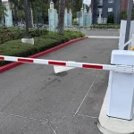 A closed red-and-white striped boom barrier blocking a parking entrance, representing a Content Security Policy blocking unauthorized scripts by default