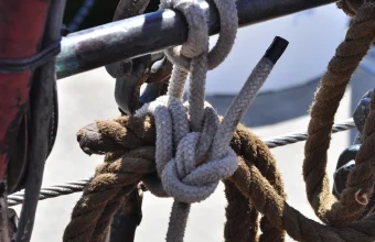 Close-up photo of a clove hitch and square knot tied in rope and rigging aboard a sailing ship