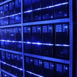 Rows of server racks with blue LED lighting stretching into the distance in a data center