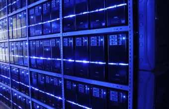 Rows of server racks with blue LED lighting stretching into the distance in a data center