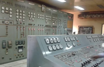 Analog gauges and switches inside an industrial power plant control room, representing the critical infrastructure systems targeted by ransomware
