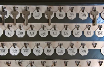A hotel-style key board with numbered tags, some slots holding keys and others empty