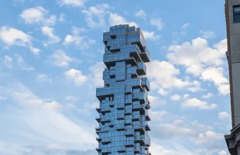 The staggered, offset glass facade of 56 Leonard Street in Manhattan, nicknamed the Jenga Building, used here as a visual metaphor for stacked financial leverage