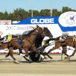 Harness racing pacers competing head-to-head on a dirt track, a visual metaphor for the AI agent harness architecture in the story