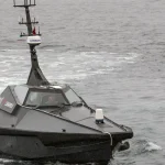 A Royal Navy autonomous surface vehicle, fitted with a mast-mounted camera and sensor array, underway during a 2020 trial exercise in Norway