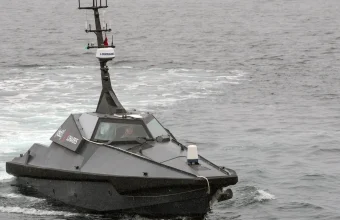 A Royal Navy autonomous surface vehicle, fitted with a mast-mounted camera and sensor array, underway during a 2020 trial exercise in Norway