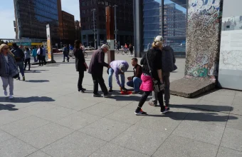 Con artists run a three-cup shell game on a table in Berlin, luring passersby to guess which cup hides the ball