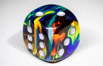 Macro photo of a single marbled six-sided die with silver pips, representing the randomness Anthropic's watermark quietly steers