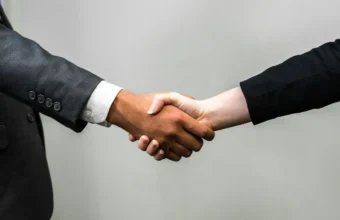 Two business people in suits shaking hands