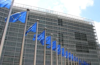 European Union flags flying outside the glass facade of the European Commission's Berlaymont building in Brussels