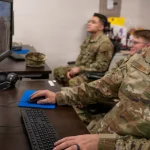 U.S. Air National Guard intelligence analysts monitor computer workstations while conducting defensive cyber operations