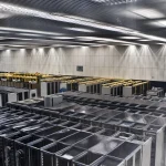 Rows of server racks seen from above in a data center, representing the physical hardware layer beneath AI inference and agent systems