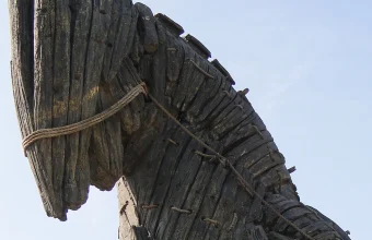 Close-up profile of the wooden Trojan Horse replica at the Canakkale waterfront in Turkey, showing weathered planks and rope bindings against a blue sky