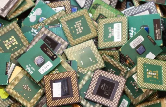 A dense pile of discarded Intel Pentium III and Celeron computer processors awaiting recycling