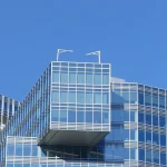 Anthropic’s $11.6 Billion Akamai Deal Flips the Usual AI Financing Script Akamai's glass headquarters tower in Cambridge, Massachusetts, with the company's logo visible on the facade