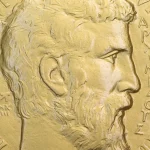Close-up photo of the obverse of a Fields Medal showing a bas-relief profile of Archimedes