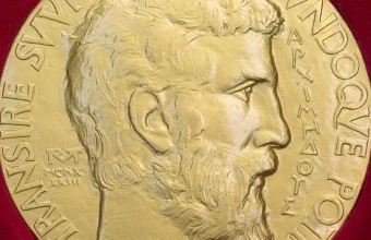 Close-up photo of the obverse of a Fields Medal showing a bas-relief profile of Archimedes