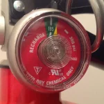 A fire extinguisher pressure gauge showing the needle in the charged green zone, a check that confirms a safety device actually works rather than just assuming it does