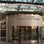 A revolving door at the entrance of Portland International Airport, used as a visual metaphor for the constant churn of enterprise AI vendor re-evaluation