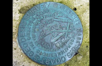 A US National Geodetic Survey reference marker set in the ground, an immutable physical reference point