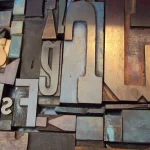Close-up of jumbled wooden letterpress printing type blocks in different letterforms and shapes